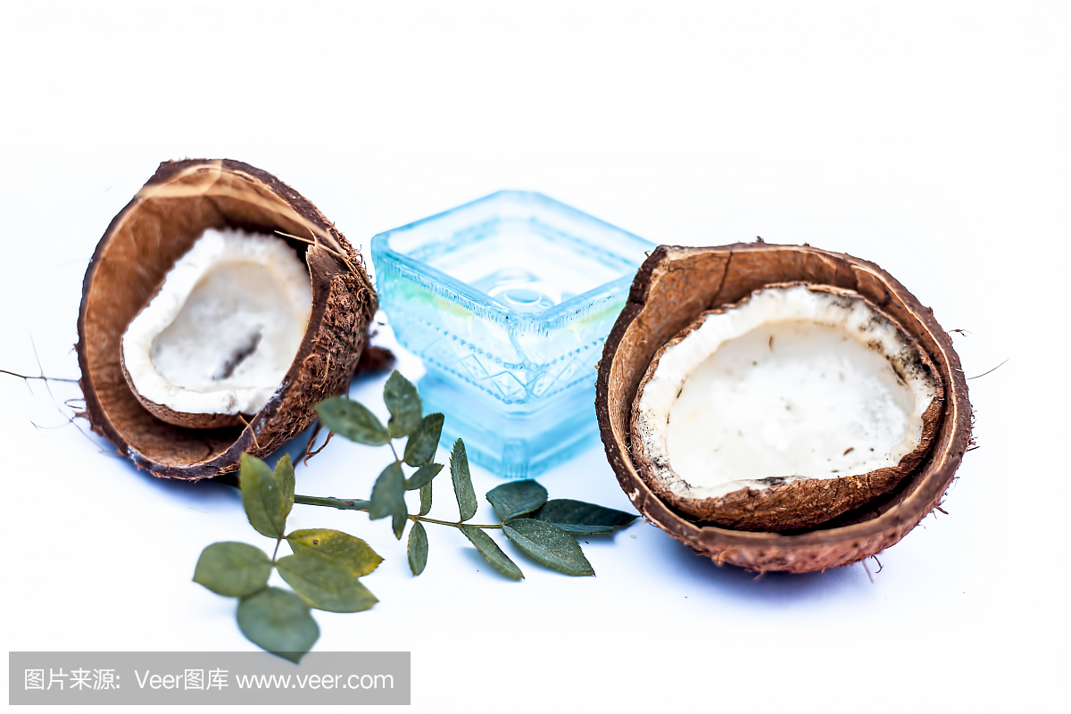 近距離的原料有機椰子油與原料椰子隔離在白色的藍色碗。